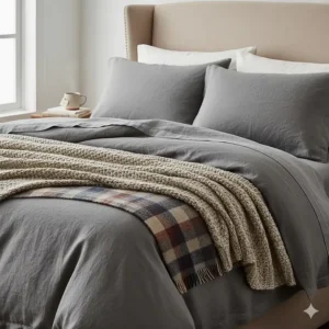 Cosy linen bedding layered with a thick wool throw for extra warmth during UK winter months.