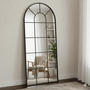 Alt text for image 5: Arched window-style full length mirror reflecting light in a small living area.