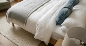 A close-up of high-thread-count Egyptian cotton bedding, a thick duvet, and a quilted mattress protector.