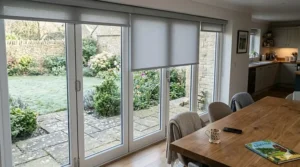 A series of individual smart roller blinds fitted perfectly to large glass bi-fold doors leading to a garden.
