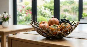 A wide-rimmed luxury fruit bowl styled on a sideboard, demonstrating high-end home decor arrangements.