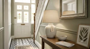 An elegant but budget-friendly ceramic table lamp sitting on a narrow console table in a bright hallway.