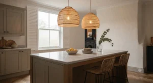 Two matching dome rattan pendant lights hanging in a row above a contemporary British kitchen island.